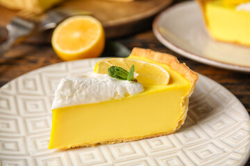 Plate with piece of tasty baked lemon pie on table, closeup