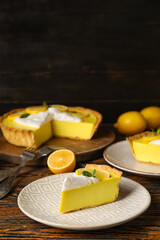 Plates with pieces of tasty baked lemon pie on table