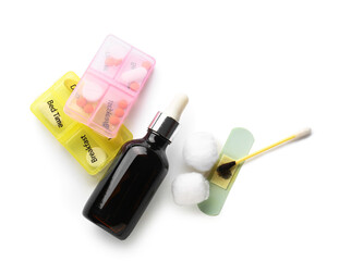 Bottle, cotton swab with iodine, plaster and containers with pills on white background