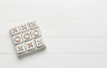Tic-tac-toe game on white wooden background