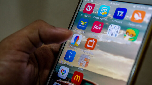 Sungai Buloh, Malaysia - July 20, 2019: An Android user touching FaceApp logo on the touchscreen to open it. Apps that edit highly realistic transformations of faces in photographs.