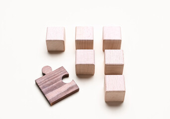 Wooden cubes with letters and puzzle piece on white background