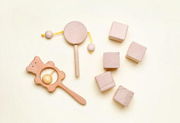 Wooden cubes with baby rattles on white background