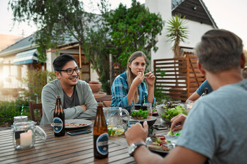 There is definitely going be leftovers for tomorrow. Shot of a young group of friends enjoying a meal together while sitting outside around a table in a garden. - obrazy, fototapety, plakaty