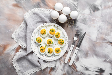Cutlery, napkin, plate and holder with eggs on grunge background. Easter celebration