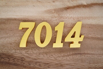 Golden Arabic numerals on a real brown and white wooden floor number 7014