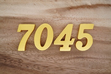 Golden Arabic numerals on a real brown and white wooden floor number 7045