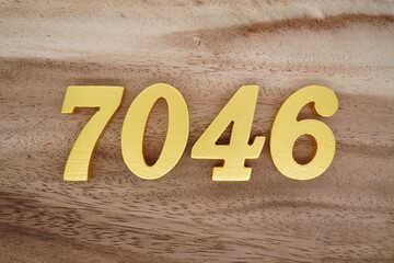 Golden Arabic numerals on a real brown and white wooden floor number 7046