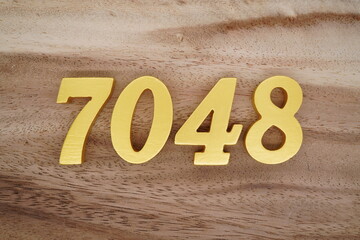 Golden Arabic numerals on a real brown and white wooden floor number 7048