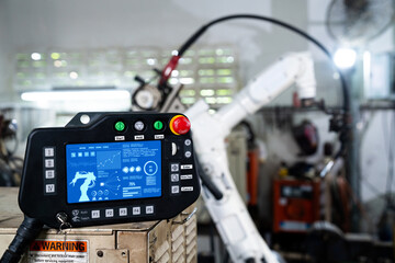 Robotic arm and its controller adept panel in a factory workshop . Industry robot programming...
