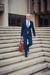 Going home after a productive day. Portrait of a confident businessman leaving his office building after a day at work.