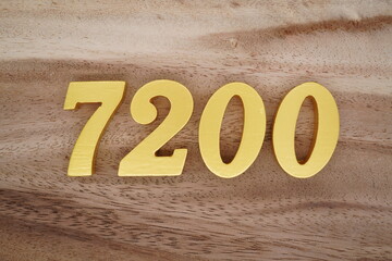 Golden Arabic numerals on a real brown and white wooden floor number 7200