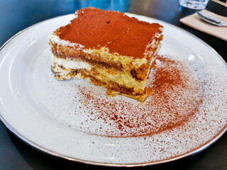 Homemade fluffy soft sweet Tiramisu Italian dessert served on white dish