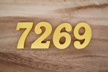 Golden Arabic numerals on a real brown and white wooden floor number 7269