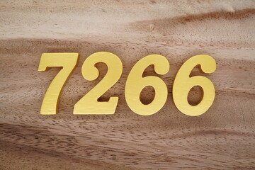 Golden Arabic numerals on a real brown and white wooden floor number 7266