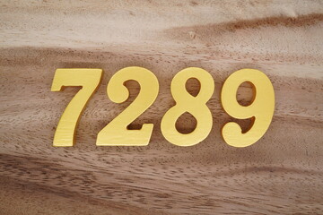 Golden Arabic numerals on a real brown and white wooden floor number 7289
