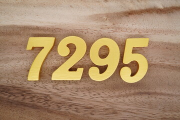 Golden Arabic numerals on a real brown and white wooden floor number 7295