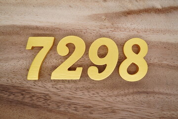 Golden Arabic numerals on a real brown and white wooden floor number 7298