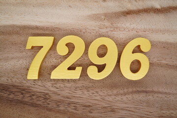 Golden Arabic numerals on a real brown and white wooden floor number 7296