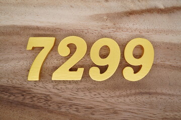 Golden Arabic numerals on a real brown and white wooden floor number 7299