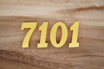 Golden Arabic numerals on a real brown and white wooden floor number 7101