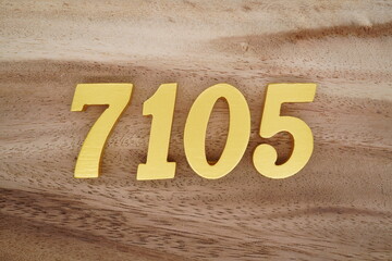 Golden Arabic numerals on a real brown and white wooden floor number 7105