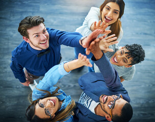 Cheers to the team-spirit. High angle shot of a group of .young businesspeople cheering in a modern...