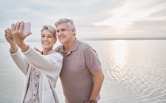 We all dream of a carefree life. Shot of a mature couple taking a selfie while at the beach.