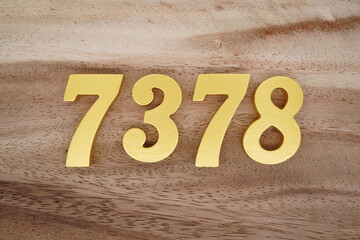 Golden Arabic numerals on a real brown and white wooden floor number 7378
