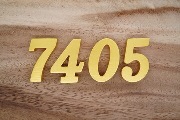 Golden Arabic numerals on a real brown and white wooden floor number 7405