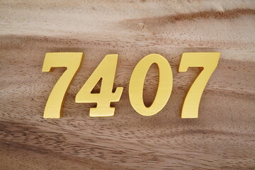 Golden Arabic numerals on a real brown and white wooden floor number 7407