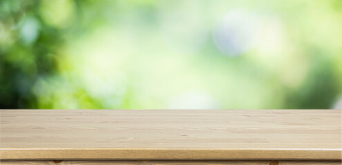 Empty wooden table with garden bokeh for a catering or food background with a country outdoor theme,Template mock up for display of product