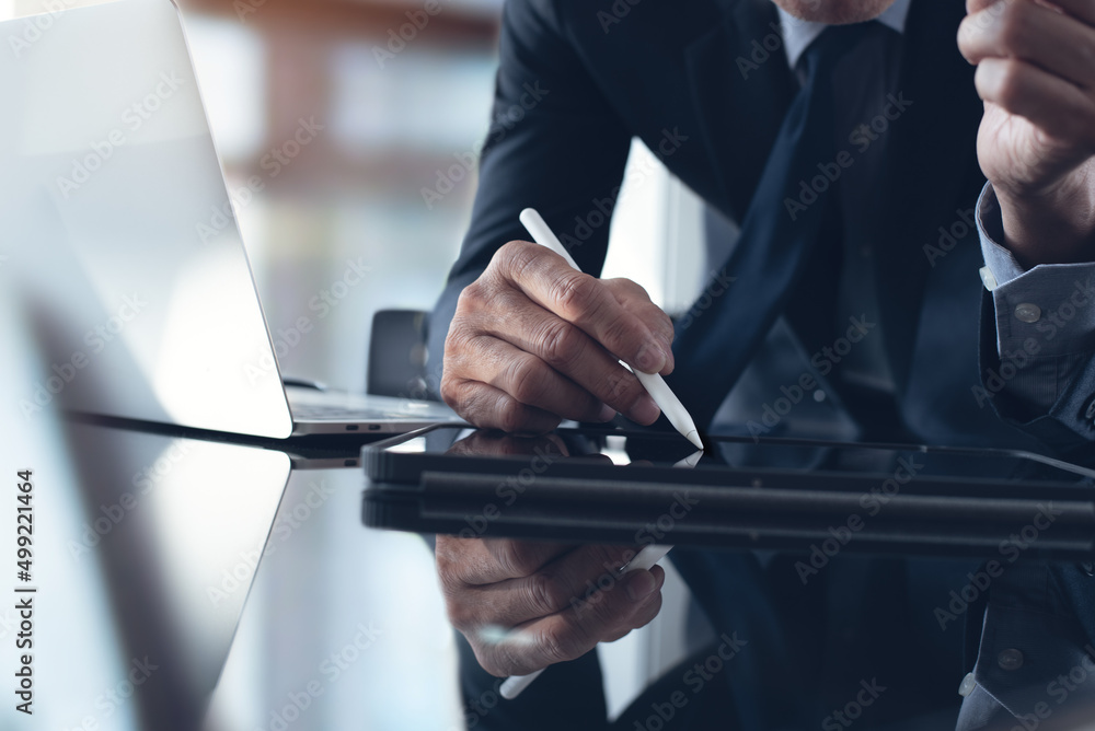 Poster businessman using stylus pen signing e-document on digital tablet with laptop computer on table at o