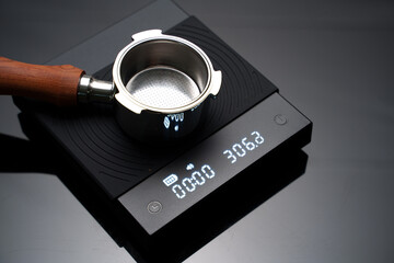 An empty bottomless portafilter on the digital coffee scale. Preparing for coffee brewing