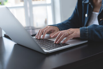Close up of asian business woman hands typing on laptop computer keyboard,  online working from home office, remotely work, telecommuting