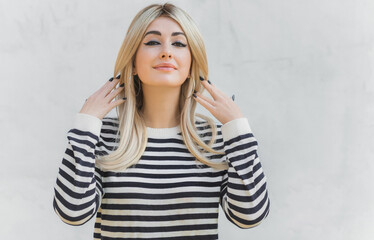 Fototapeta premium 60s-70s look. Woman blonde hair vintage makeup wear striped jumper, fashionable concept
