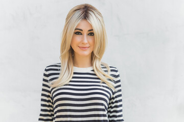 60s-70s look. Woman blonde hair vintage makeup wear striped jumper, fashionable concept