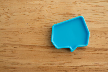 Chat bubbles on social media communication. Blue chat bubbles icon messages on wooden background...