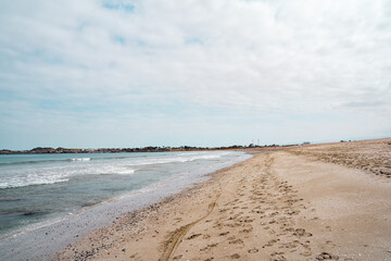 Obraz premium Horizontal side view of the coastline on a beach on a cloudy day.