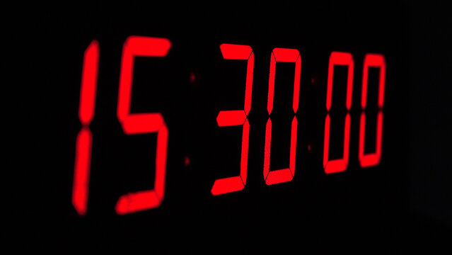 Digital timer on a black background. Light panel with red numbers