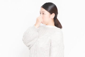 悪臭に困って鼻をつまんでいる女性