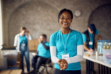 Young happy black woman working as volunteer at community center.
