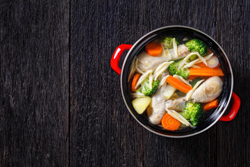 chicken vegetable soup with pasta in red pot