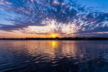 Obraz premium A pink sunrise over the Saint Sebastian River on an overcast day in Little Hollywood, Mikko, Florida. Dramatic colors of nature on a Florida morning