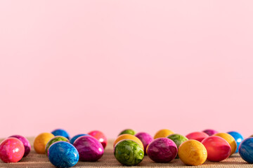 Scattered colored chicken eggs on linen fabric. Easter.