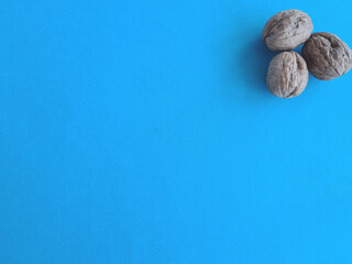 Closeup of whole walnuts on blue background