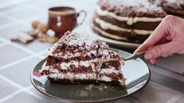 Hungry woman cut out slice from homemade chocolate cake