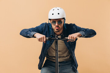 Stylish modern man in a helmet on an electronic scooter, photo in the studio