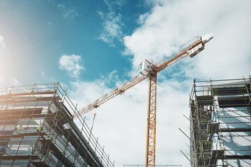 Is it a bird Is it a plane No, its a crane. Shot of a crane and building at a construction site.