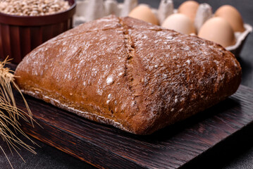 Beautiful tasty, square-shaped brown bread on a dark concrete background